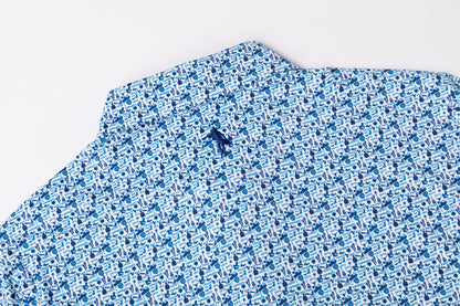 A close-up of a blue and white patterned fabric, likely a shirt or scarf, featuring a small embroidered dark blue logo on the collar, set against a plain white background.