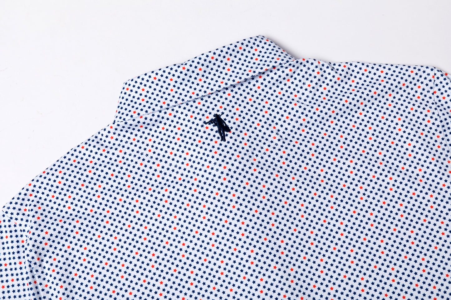 Folded shirt with a small black logo on a light gray background