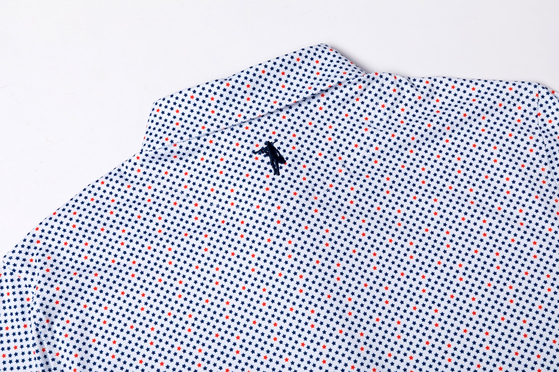 Folded shirt with a small black logo on a light gray background