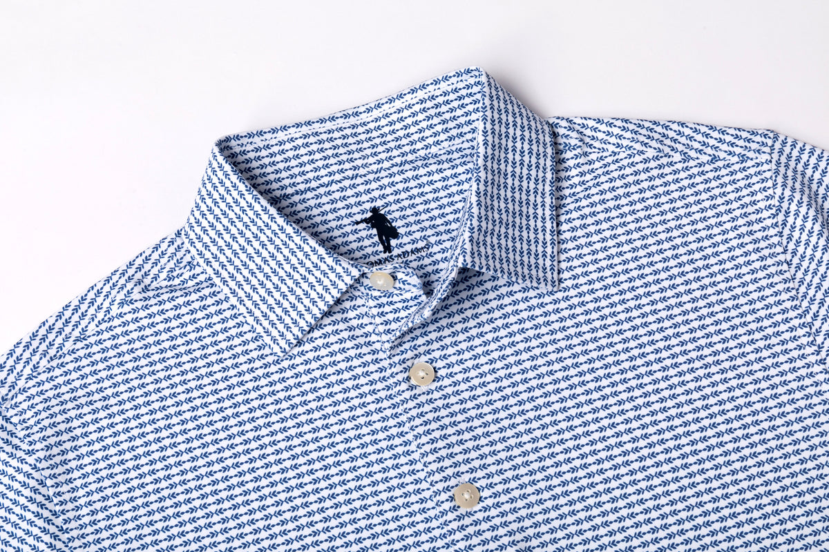 Close-up of a blue and white micro-patterned button-down shirt collar with white buttons, laid flat on a white background.
