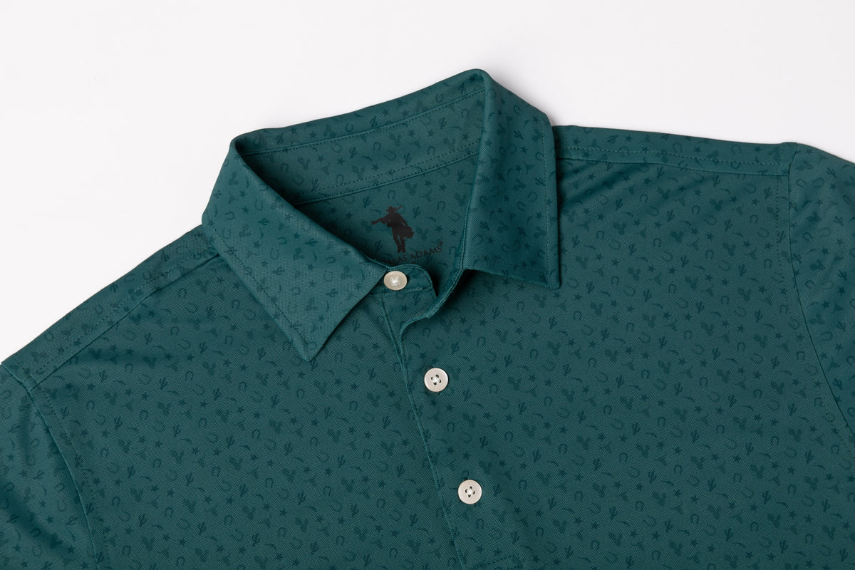 A close-up of a dark green long-sleeve button-down shirt with a subtle repeating micro-pattern, featuring a classic collar and white buttons.
