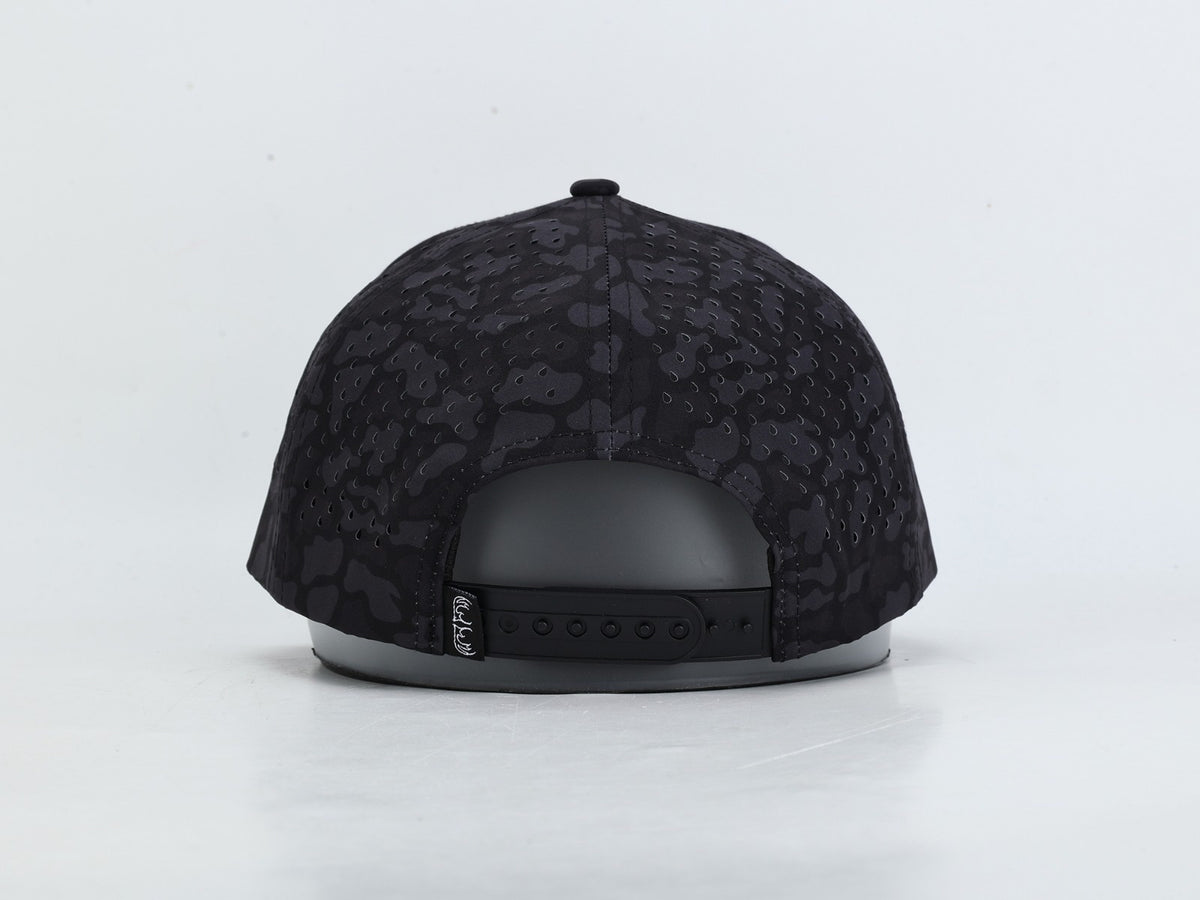 Black snapback cap with a subtle tonal camouflage pattern, shown from the back on a light gray background.